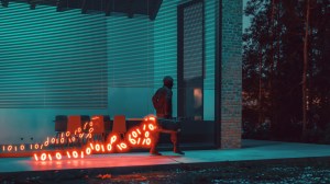 A figure walking with a glowing trail of binary code emanating from a case, symbolizing stolen data. (Getty Images Plus)