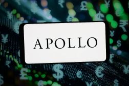 The logo of Apollo Global Management is displayed on a smartphone in front of abstract background. (Photo Illustration by Timon Schneider/Getty Images)