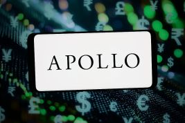 The logo of Apollo Global Management is displayed on a smartphone in front of abstract background. (Photo Illustration by Timon Schneider/Getty Images)
