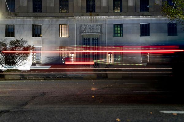 Light trails from a passing vehicle are seen in front of the Department of Justice building in Washington on November 21, 2021. (Stefani Reynolds for The Washington Post via Getty Images)